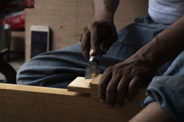 Marangoz atölyesinde masasında oymayla çalışıyor.