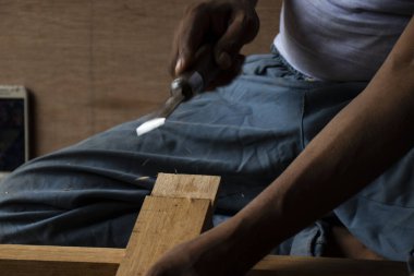 Marangoz atölyesinde masasında oymayla çalışıyor.