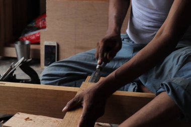 Marangoz atölyesinde masasında oymayla çalışıyor.