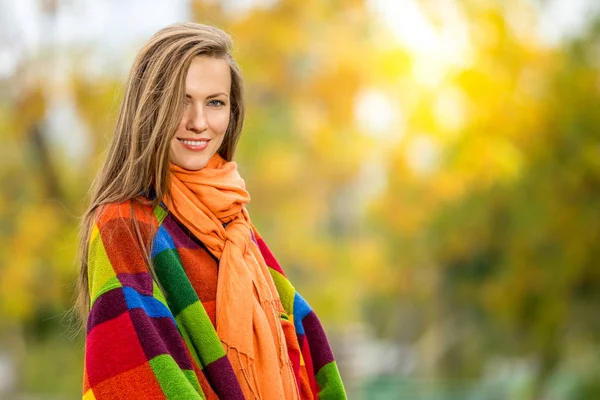 Glückliche junge Frau im Park an einem sonnigen Herbsttag — Stockfoto