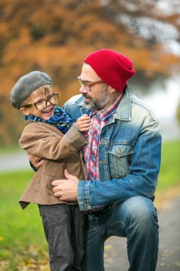 Baba ve oğul sonbahar sahne parkta oynarken