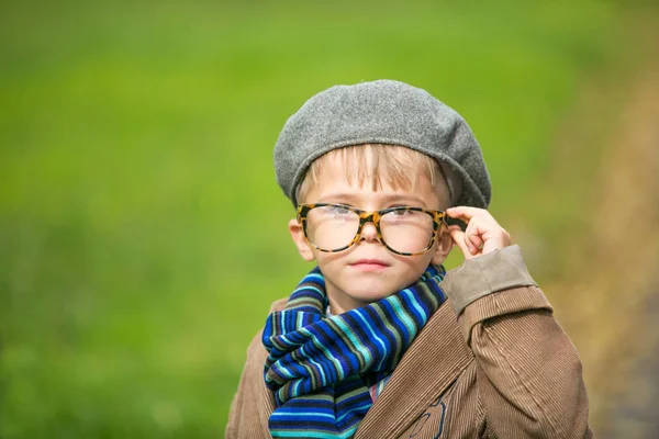 Симпатичный стильный мальчик в теплой одежде в осеннем пейзаже — стоковое фото