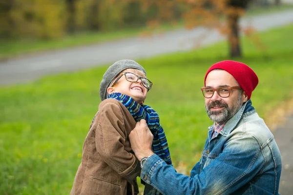 Baba ve oğul sonbahar sahne parkta oynarken — Stok fotoğraf