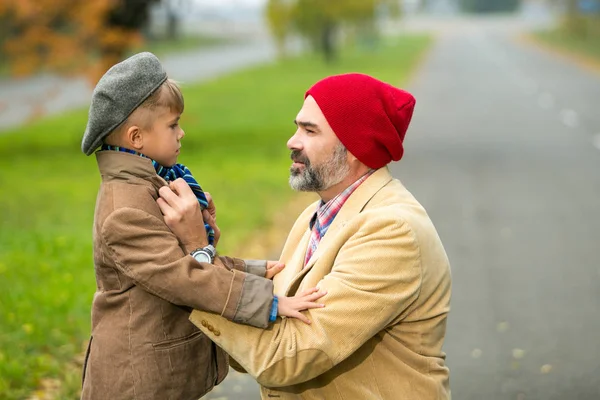 Father and son playing in the park in autumn scenery — Stock Photo, Image