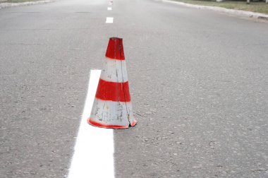 Trafik konisi yolda, beyaz trafik şeridi ayırıyor.