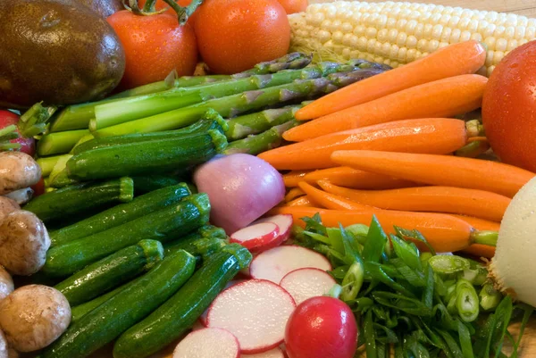 Legumes variados, incluindo milho, cenouras, tomates, rabanete, espargos, cogumelos, cebolas, abobrinha e batatas Imagem De Stock
