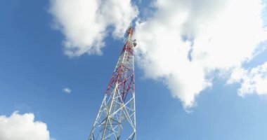 Aşağıdaki iletişim kulesinin videosu. Arkasında beyaz bulutlar var..