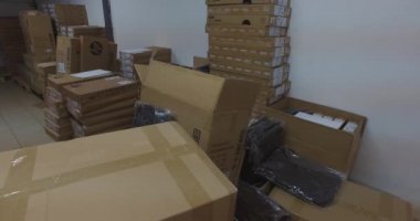 Çin, Hong Kong - 2 Mart 2020. Arka planda çeşitli üreticilerin kutularının olduğu editör videosu ve ön planda da gönderilmeye hazır Ebay videosu. Kayıt bir depoda değil, sahnelenmiş bir çevrede yapılmış..