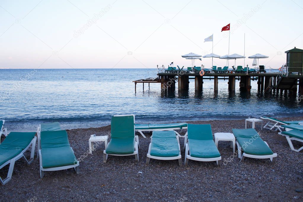 Comfortable sunbed at summer resort beach. Exotic travel destination for summer vacation. Deep blue sea water,cloudy sky. Turkey, the Mediterranean Sea