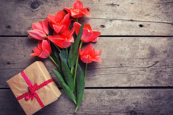 Bouquet de tulipes de corail et boîte enveloppée — Photo