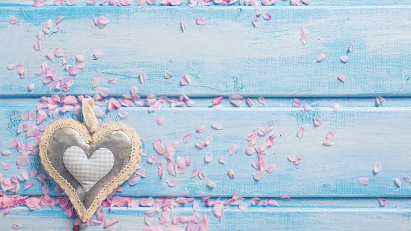 Dekorativt hjärta och rosa kronblad o — Stockfoto