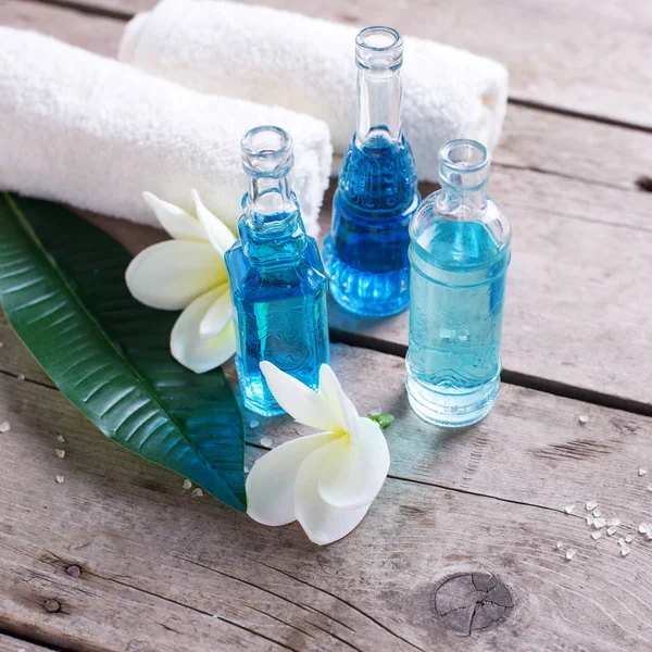 Bottiglie con olio aromatico e fiori — Foto Stock