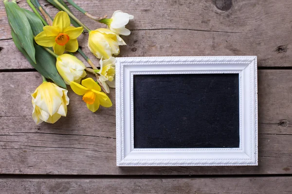 Spring flowers and empty blackboard — Stock Photo, Image