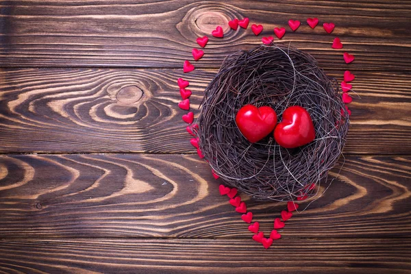 Маленькие сердца в гнезде на деревянном фоне . — стоковое фото