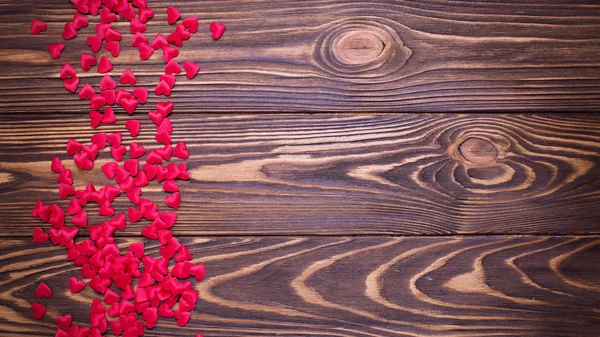 Many little hearts on  wooden background. — Stock Photo, Image