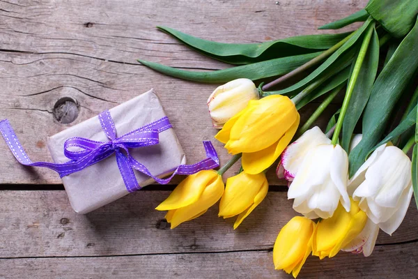 Helle Frühlingstulpen und gewickelte Schachtel mit Geschenk — Stockfoto