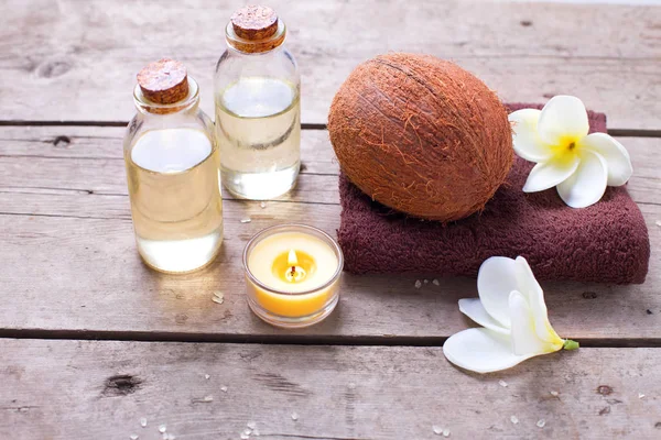Bottles with coconut oil and towels — Stock Photo, Image