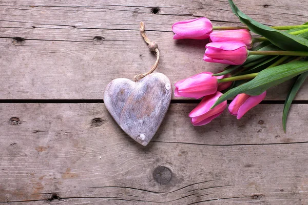 Luminosos tulipanes rosados y corazón rústico decorativo — Foto de Stock