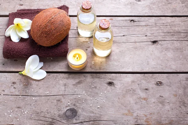 Bottiglie con olio di cocco e asciugamani — Foto Stock