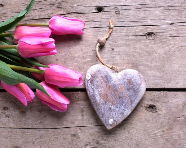 Parlak pembe laleler ve dekoratif rustik kalp 