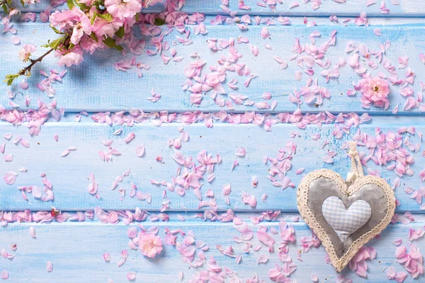 Квіти сакури та декоративне серце на синіх дерев'яних дошках . — стокове фото