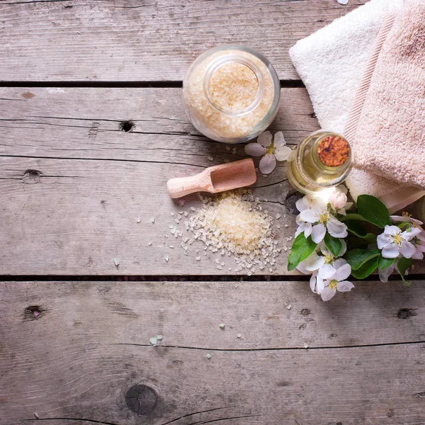 Sea salt, towels, aroma oil in bottles and flowers — Stock Photo, Image