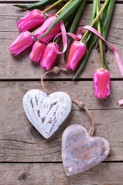 Весенние тюльпаны и два декоративных сердца — стоковое фото