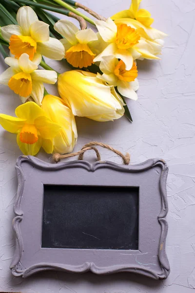 Žluté květy a prázdný rámeček na šedý podklad s texturou. — Stock fotografie