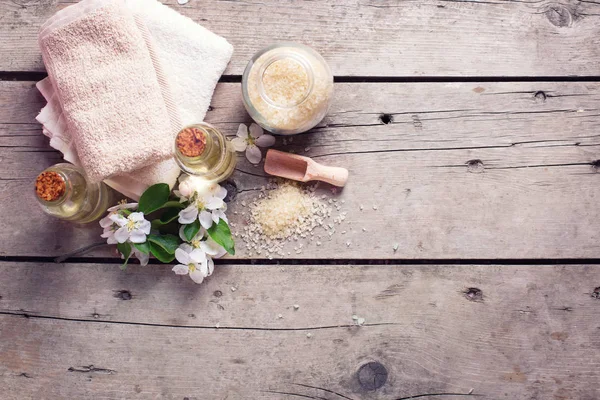 Sea salt, towels, aroma oil in bottles and flowers — Stock Photo, Image