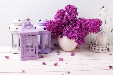 Muhteşem Eflatun çiçekler ve fenerler Beyaz ahşap zemin üzerinde.