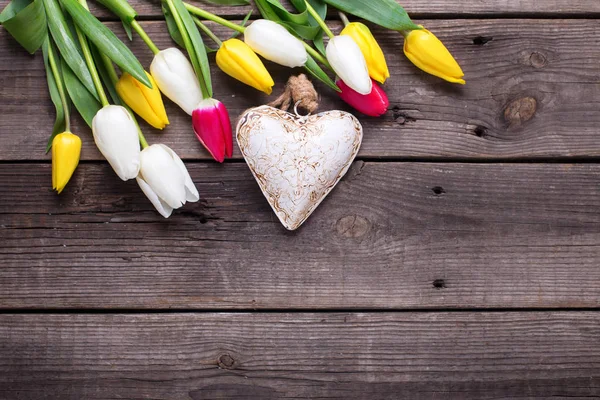 Διακοσμητική καρδιά και φωτεινά ανοιξιάτικα λουλούδια τουλίπα — Φωτογραφία Αρχείου