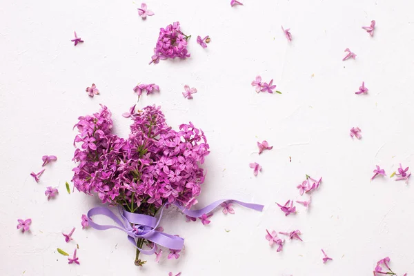 Μάτσο υπέροχα λιλά λουλούδια σε γκρι φόντο με υφή. — Φωτογραφία Αρχείου