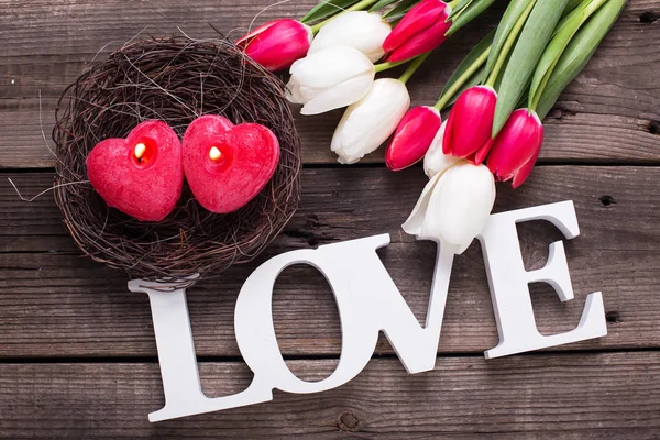 Palavra amor, duas velas vermelhas em forma de coração — Fotografia de Stock