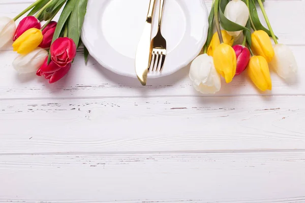 White plate, cutlery and tulips — Stock Photo, Image