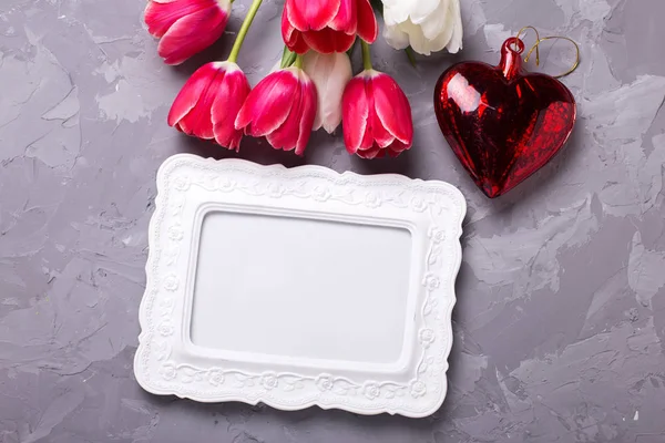 Порожня рамка, тюльпани та декоративне серце — стокове фото