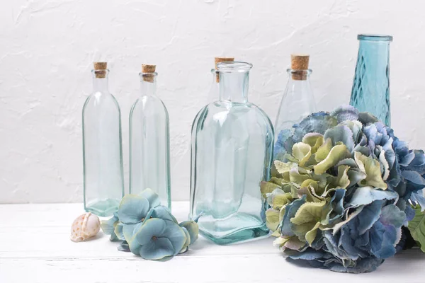 Flaskor, blå hortensia blommor och skal — Stockfoto