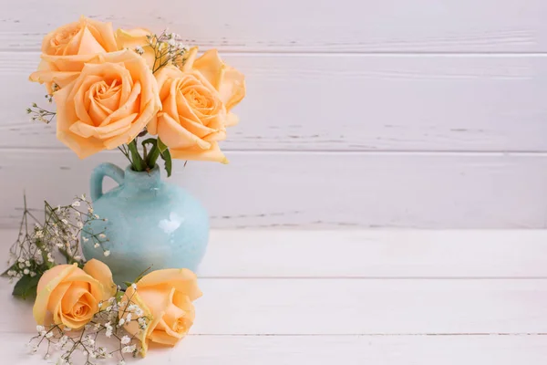 Brzoskwiniowy róż kwiaty w wazonie niebieski — Zdjęcie stockowe