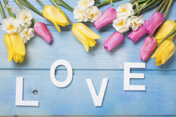Word love and  pink, yellow and white flowers 