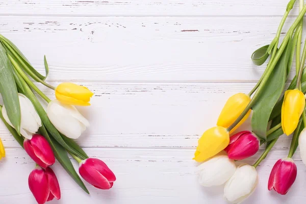 Rahmen Aus Gelben Rosa Und Weißen Tulpenblüten Auf Weißem Holzgrund — Stockfoto