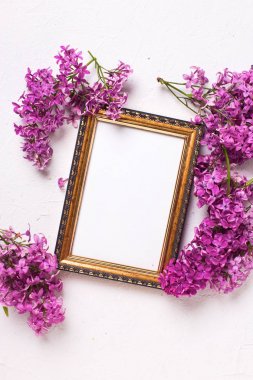 Taze leylak çiçekler ve boş çerçeve gri dokulu arka plan üzerinde. Üstten Görünüm. Kadar alay et. Metin için yer.