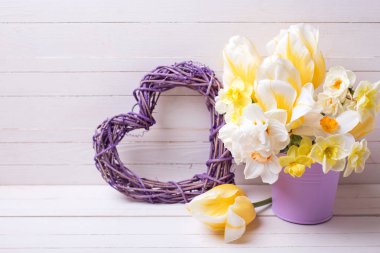 Sarı nergis ve Lale mor ot ve Beyaz ahşap zemin üzerinde dekoratif kalp. 