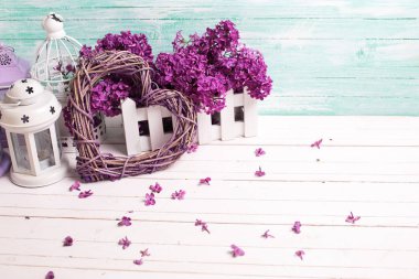 Taze leylak çiçekler, dekoratif kalp ve fenerler turkuaz duvara Beyaz ahşap zemin üzerinde. Seçici odak. Metin için yer.