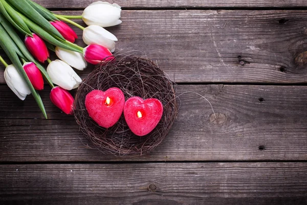Dwie Czerwone Świece Postaci Serca Gnieździe Jasne Wiosną Tulipany Rustykalne — Zdjęcie stockowe