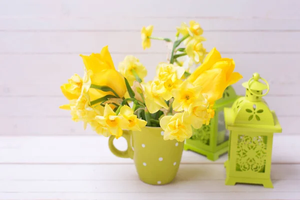 春に明るい黄色の水仙や水仙花グリーン カップと軽い木製の背景に装飾的な緑提灯 選択と集中 イースターの背景 — ストック写真