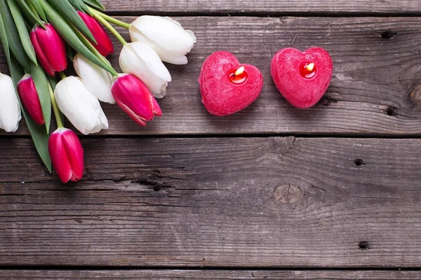 Dos Velas Rojas Ardientes Forma Corazón Flores Tulipanes Brillantes Sobre — Foto de Stock