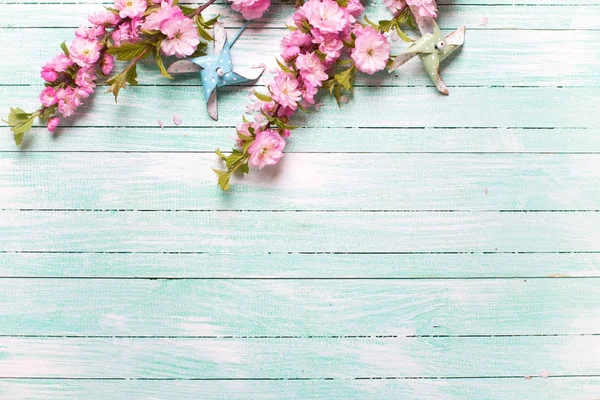 Розовые Миндальные Цветы Декоративные Ветряные Мельницы Бирюзовом Деревянном Фоне Вид — стоковое фото