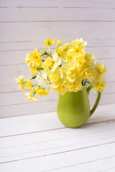 ピッチャー白い木製の背景の上に明るい黄色春水仙花 — ストック写真