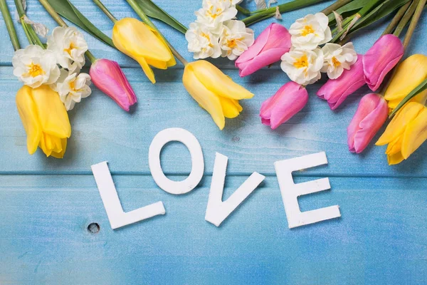 青い木製の背景上の愛とピンク 黄色と白の花を単語します 愛の概念 選択と集中 — ストック写真
