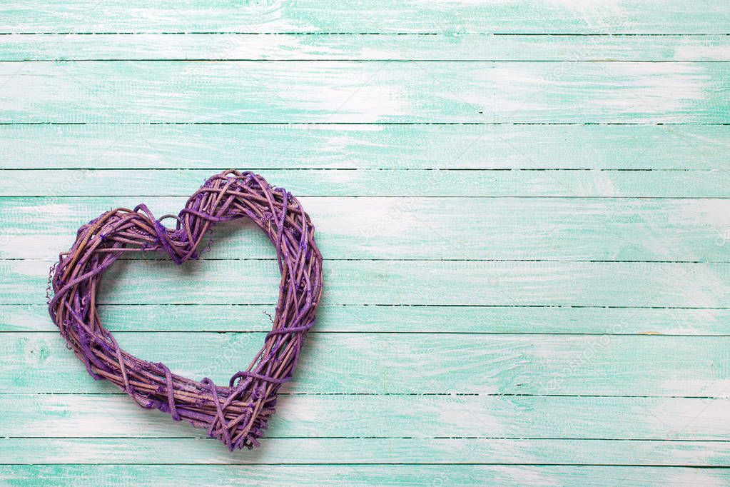 Decorative heart on turquoise wooden background.Top view with copy space