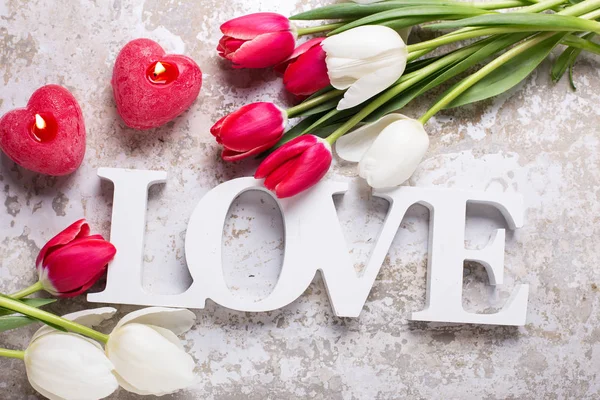 Word Liefde Twee Rode Kaarsen Vorm Van Hart Helder Lentebloemen — Stockfoto